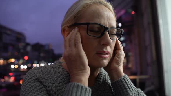 Tired Mature Woman Massaging Temples Feeling Headache, Hustle of Big City