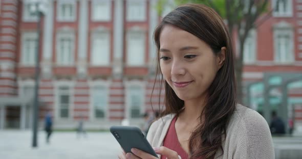 Woman check on mobile phone in Tokyo station of Japan alt