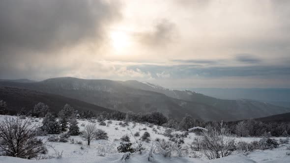 Mists and snowfall over the snow-covered mountain slopes alt