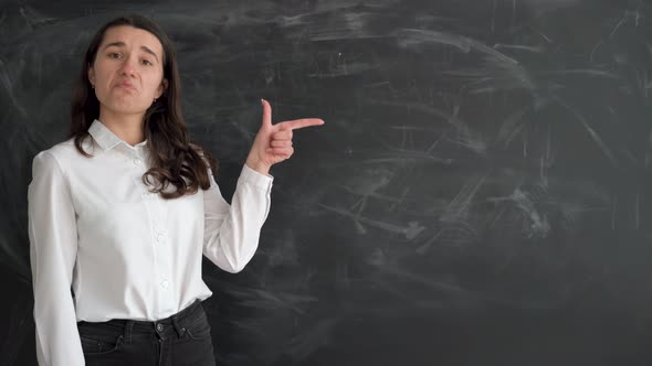 Caucasian Student Girl Stands Near the Chalk Board Raises Her Index Finger and Points to an Empty alt