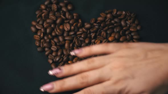 Coffee Beans Lie in the Form of a Heart Their Female Hand Cleans Them alt