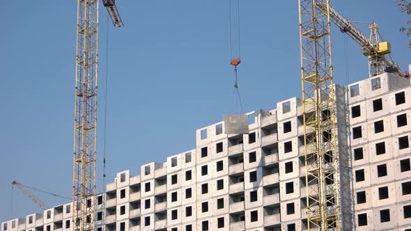 Yellow Crane Lifts Up Concrete Floor on the Building alt