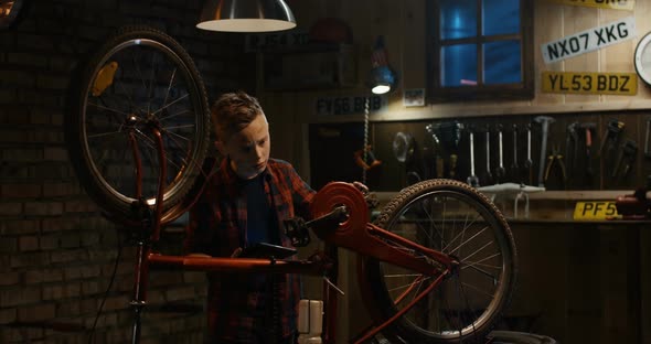 Teen Boy Repairs Bicycle alt