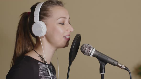 Cute Woman in Headphones Sings Song in Microphone, Streaming Solo Concert