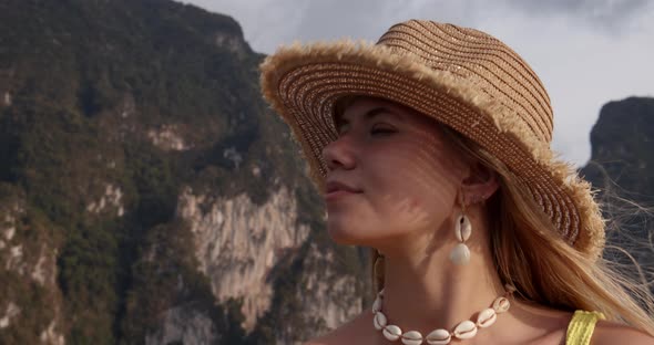 Beautiful Female Traveler with Her Eyes Closed and View of the Rocky Mountains alt