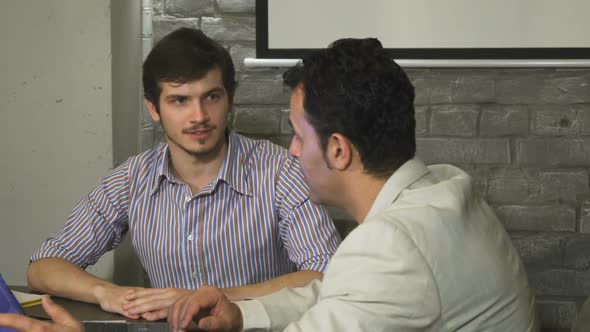 Young Businessman Having a Meeting at the Office with His Mature Colleague alt