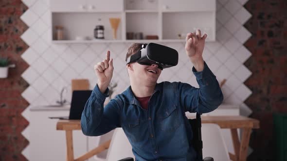 Man in Wheelchair Using Virtual Reality Helmet or Glasses at Hom