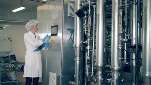 Factory Worker in Uniform Checks Plant Industrial Equipment, Food and Drinks Production Machines alt