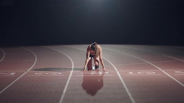 The Woman at the Start of the Race Gets Into the Pads Rises and Runs in Slow Motion in the Evening alt
