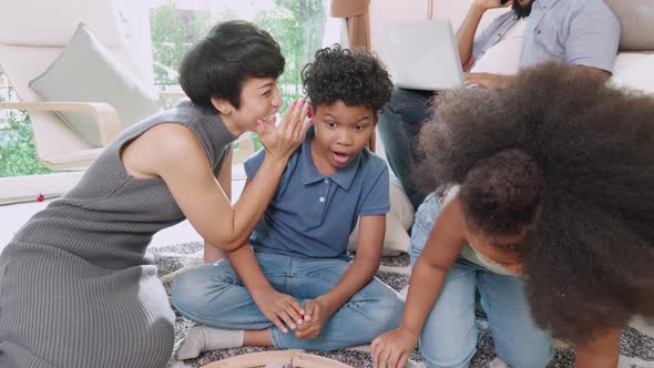 Full length happy African American family play together on floor at living room