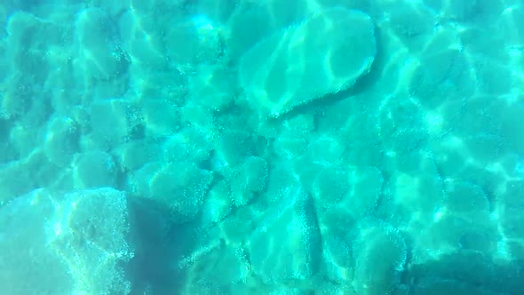 Blue Water Surface with Ripple and Stones on a Bottom.