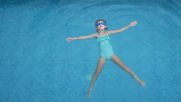 Girl Child Swims in the Pool Underwater View of the Pool From Above