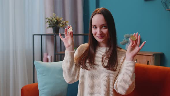 Woman Freelancer Holding Two Gold Coins BTC at Home Successful Developer Programmer Stock Trader alt