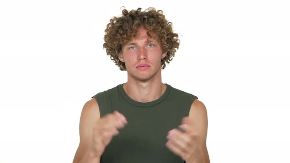 Portrait of Handsome Guy with Curly Hair in Green Muscle Shirt Being Emotionless Looking on Camera alt
