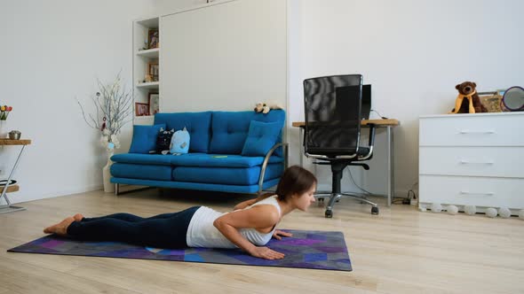 Young Woman Doing Cobra Yoga Pose At Home