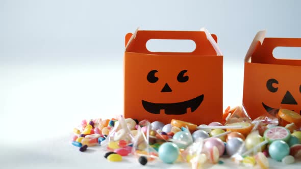 Halloween box with various candies on white background 4k alt