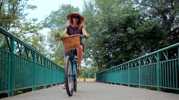 Woman Cyclist Happy On Bicycle. Hair Blowing When Girl Cycling Bike. Cyclist Wearing Dress Workout. alt