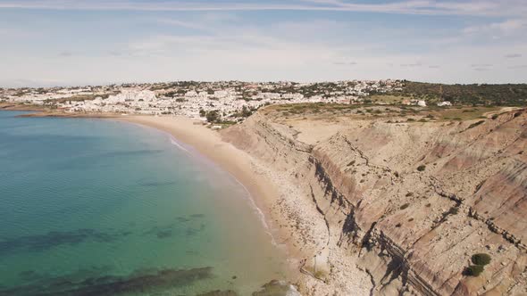 Steep Limestone cliff bordering Praia da Luz along Algarve Coast - Aerial alt