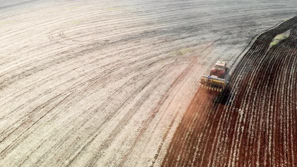Tractor with seeder in the field. Sowing of corn, Maize in soil, with pneumatic sowing machine durin alt