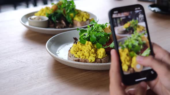 Lifestyle Blogger Tacking Videos and Photos of Fresh Morning Toasts with Scrambled Eggs for Social alt