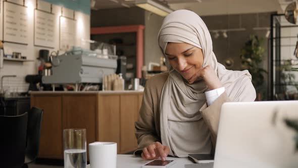 Muslim Woman on Remote Working Online Education or Video Conversation in Caffe alt