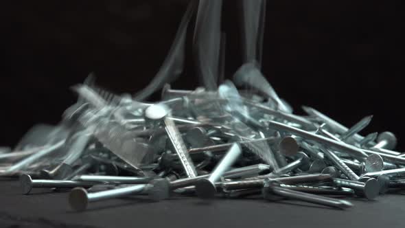 Metal Steel Nails for Construction Work Falling on a Rotating Surface on a Black Background Hobnails alt