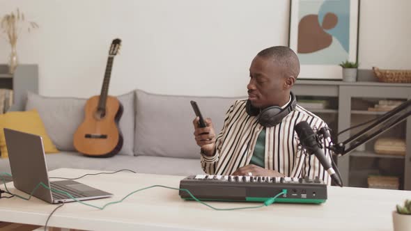 African Artist Playing Midi Synthesizer while Having Video Conversation alt