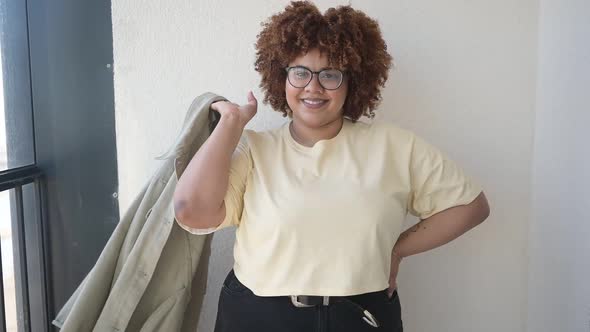 Beautiful Happy Smiling Curvy Plus Size African Black Woman Afro Hair Posing in Beige Tshirt Jeans