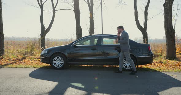 Young Businessman Calling for Car Service on Roadside Assistance After Broken Car alt