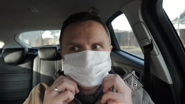 The Driver of the Car Puts on a Medical Mask