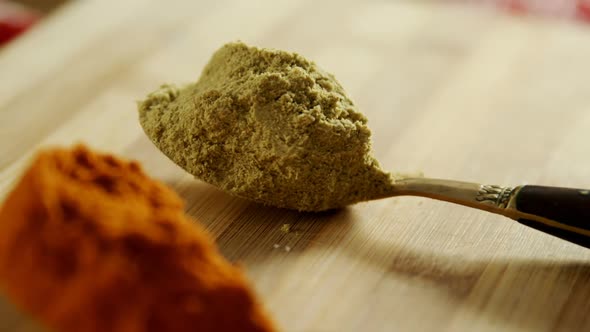 Turmeric powder, ed chili powder and coriander powder on a wooden table 4k alt