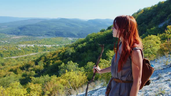 A Woman is Walking Along a Mountain Path alt