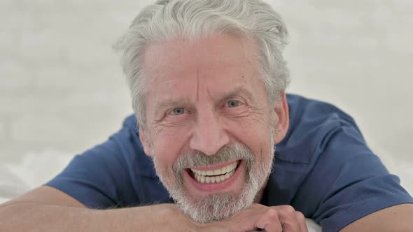 Smiling Old Man Lying on Front alt