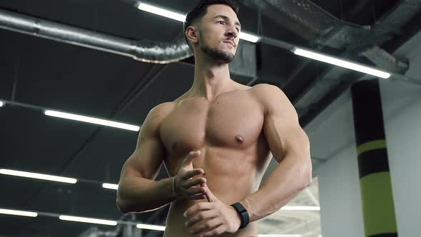 Attractive Young Man Without t-shirt Rub His hands on the Gym Background alt