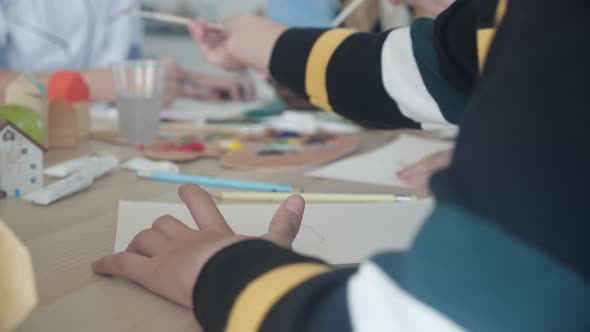 Closeup group of student sitting and studying and learning drawing with teacher together. alt