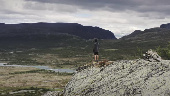 Drone Of Boy Standing On Cliff In Landscape alt