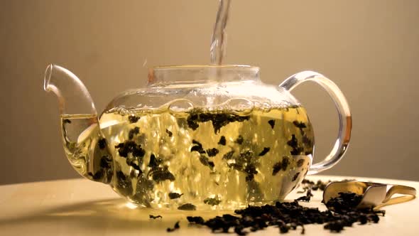 Water Pouring in Teapot with Green Tea