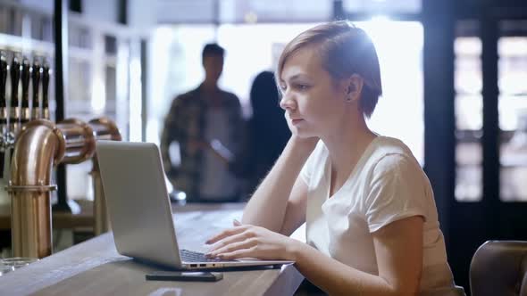 Woman with Gadgets Working at Bar alt