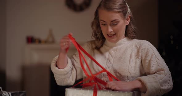 Woman Unpacking Gift at Christmas alt