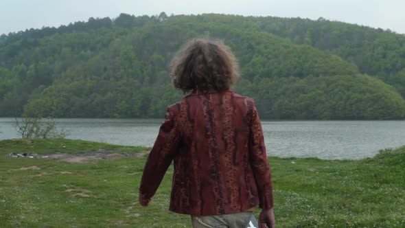Guitarist Man Walking Near Lake