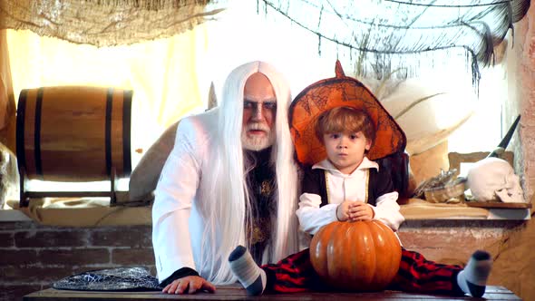 Grandpa and Grandson with Pumpkin Together As Preparation for Halloween, Cheerful Children  alt