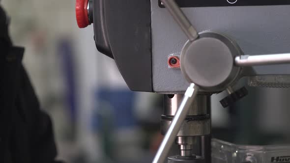 Hand Moving Down Pilot Feed Lever Of A Drill Press Machine (Boor Machine) - close up alt