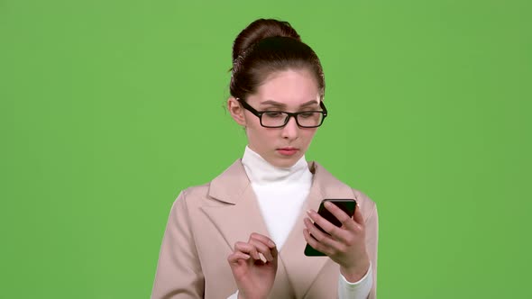 Girl Looks at the Phone and Is Surprised at What She Saw. Green Screen. Slow Motion alt