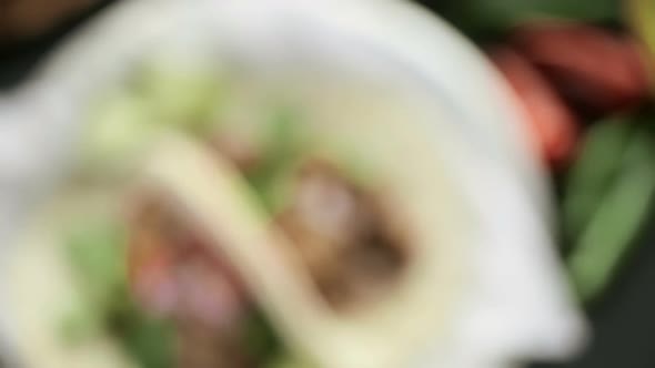 Close up of pulled pork carnitas with pico de gallo on a flour tortilla. alt