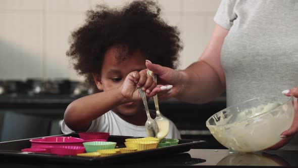 Mixed Family Making Cupcakes  Pouring Raw Liquid Dough in the Cake Moulds alt