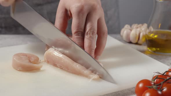 A man slices a chicken fillet