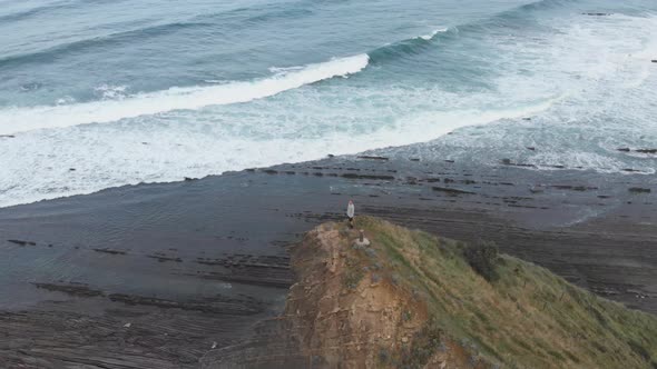 Aerial drone shot of a man over a cliff. Stunning nature landscape. Freedom feeling. Orbit shot. Clo alt