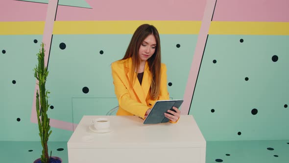 Woman In Yellow Jacket Uses Tablet Computer