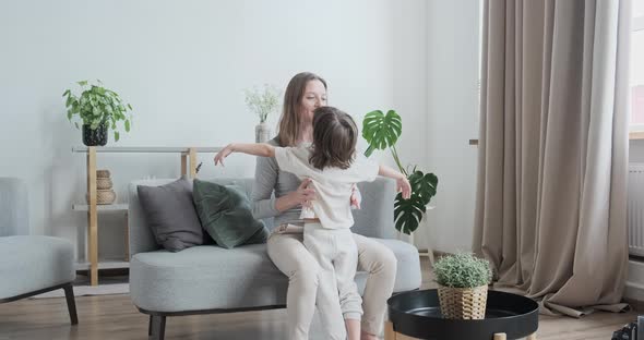 Happy Young Mother Hugging Cheerful Son Kid Playing Together Having Fun at Home Interior alt