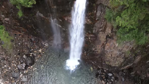 Rising up quickly revealing dense forest surrounding Franklin Falls, aerial alt